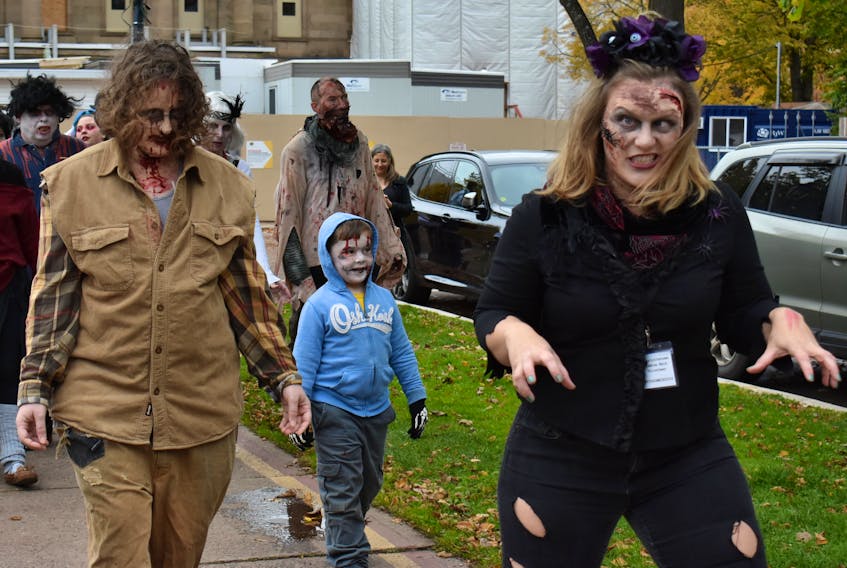 Lindsey Ross, right, and her sister Amelia Lockert shamble along in front of a zombie horde, descending on Charlottetown on Oct. 19, 2019 for the Red Island Apocalypse Zombie Walk.