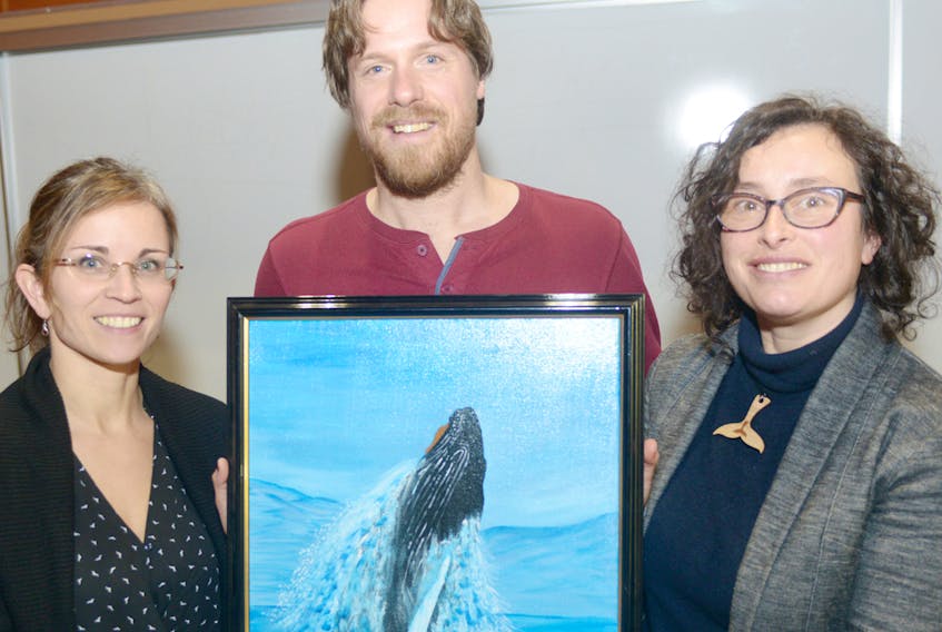 Marine Animal Response Society Tonya Wimmer, from left, Save Our Seas and Shores P.E.I. chair Colin Jeffrey and Sierra Club Canada Foundation national program director Gretchen Fitzgerald up a painting of a whale following a fundraiser at UPEI on Jan. 21, 2018 in support of increased protection of the Gulf of St. Lawrence.