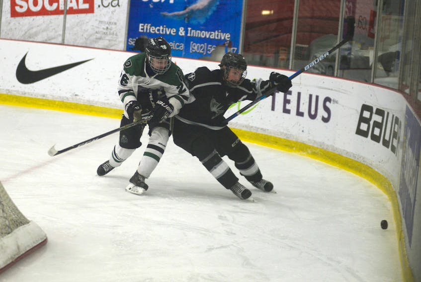 Riley MacDougall, left, of the Charlottetown Bulk Carriers Pride, battles Northern Moose captain Frederick Castonguay for the puck during Friday's major midget game at MacLauchlan Arena.