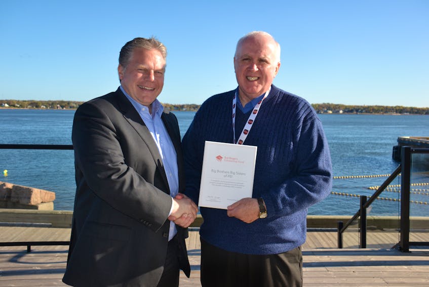 James Rajotte, vice president for provincial and municipal government relations with Rogers Communication presents Myron Yates, executive director of Big Brothers, Big Sisters P.E.I. with a $25,000 grant to go towards the organization’s teen mentoring program.