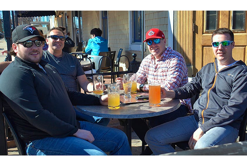 Jordan Hallett, Lou Gibson, Craig Vaughan and Jaret LeBlanc of Fredericton take a break from a conference they were attending in Charlottetown to enjoy a cool beverage on the patio at Hunter’s Ale House on Monday. Temperatures reached a high of 13 C on Monday.  The thermometer is expected to reach 16C in the capital city today.  ©THE GUARDIAN