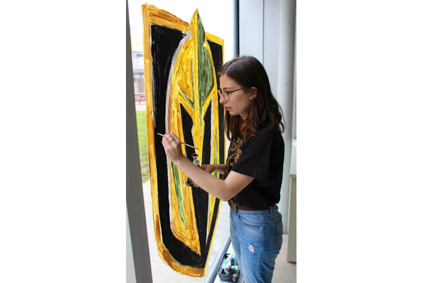 Theodora Bujenita paints a Vegas Golden Knights logo on one of Credit Union Place’s many windows on Wednesday afternoon. The City of Summerside is encouraging local businesses and residents to show their support for the team as its head coach is from Summerside.