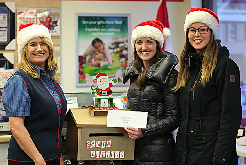 Canada Post letter carriers are preparing to collect letters to Santa just prior to the Charlottetown Christmas Parade on Saturday, Nov. 25. From left, Canada Post employee Pauline MacIntyre showcases the Santa Letters mailbox along with City of Charlottetown employees Laurel Lea, tourism officer, and Charlotte Nicholson, special events assistant at the downtown Canada Post office.  ©THE GUARDIAN