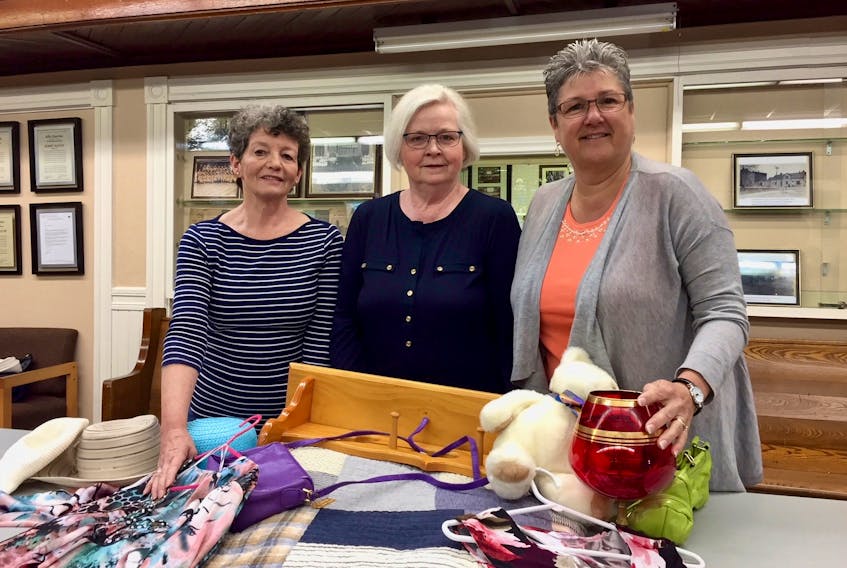 Heather Holdway, left, Gail Burt, center, and Lynn Trowsdale display a few of the many items that will be on sale at the Zion Presbyterian Church annual spring sale June 1 and 2. The church is located at 135 Prince Street in Charlottetown at the corner of Prince and Grafton streets.