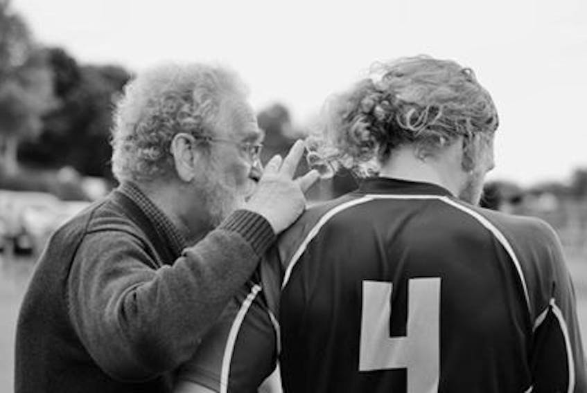 Raymond Moore, left, is pictured counselling a player on the sideline of a rugby pitch. Moore is going into the P.E.I. Rugby Union Hall of Fame for his work as an organizer, coach and administrator.