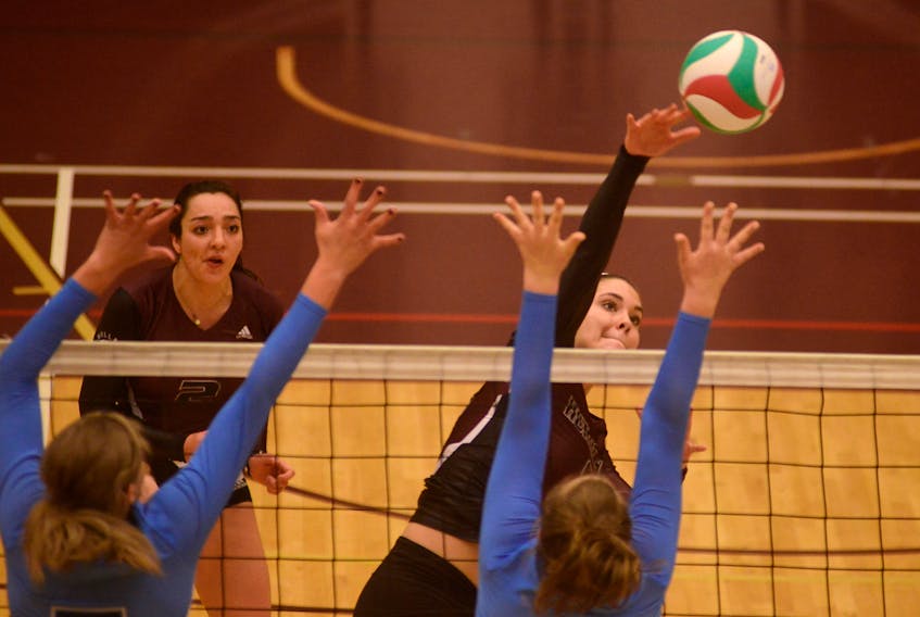 Holland College Hurricanes middle Brittany States, right, hits away from the Mount Saint Vincent Mystics block Sunday during Atlantic Collegiate Athletic Association women’s volleyball action in Charlottetown. Jason Malloy/The Guardian