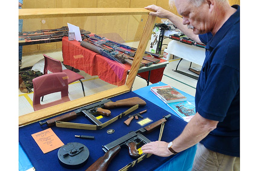 Sackville resident Peter Ripley shows his Thompson submachine guns during the third annual P.E.I. Gun and Memorabilia show at North Shore Community Centre on the weekend. The firearm, often referred to as a “Tommy gun,” is one of the most recognizable in the world but is prohibited to most Canadians.  ©THE GUARDIAN/Mitch MacDonald