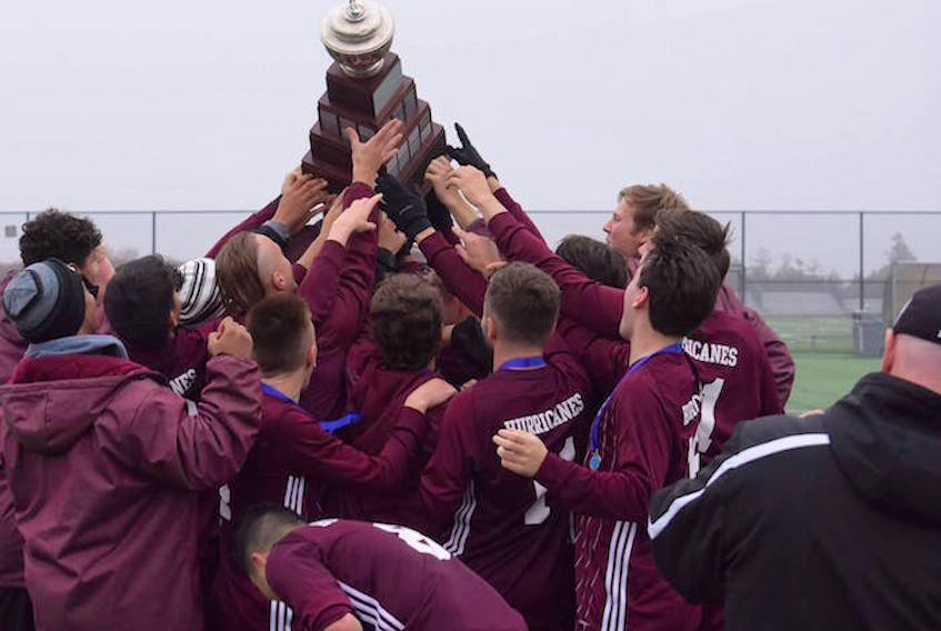 The Holland College Hurricanes celebrate with the trophy after winning the Atlantic Collegiate Athletic Association men’s championship Sunday in Halifax, N.S. It was the school’s fifth straight title.