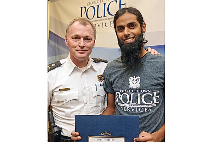 Omair Imtiaz, right, receives a certificate from Charlottetown deputy police chief Brad MacConnell after graduating from the Citizen Police Academy. Imtiaz described the academy as an eye-opening experience that gave him a greater appreciation for the work of law enforcement.  ©THE GUARDIAN