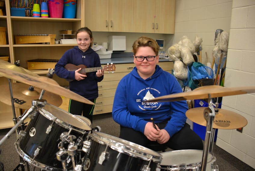 Grade 6 students Kayla MacDonald, left, and Jaxsen Carragher display some of Stratford Elementary School’s instruments like the ones that will soon be rolling out across the province as part of a $300,000 purchase.