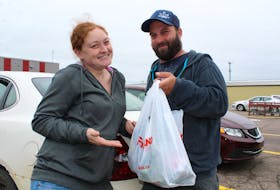 Lorren Assayag and Adam Romphf of York hold up the last plastic bag they’ll ever receive from a P.E.I. grocery store on Sunday. A ban is now in effect preventing retailers from using plastic bags. KATHERINE HUNT/THE GUARDIAN