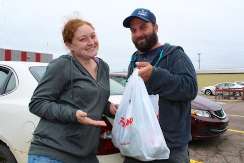 Lorren Assayag and Adam Romphf of York hold up the last plastic bag they’ll ever receive from a P.E.I. grocery store on Sunday. A ban is now in effect preventing retailers from using plastic bags. KATHERINE HUNT/THE GUARDIAN