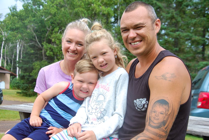Vacationing at Marco Polo Land campground in Cavendish is a welcome break for Vicky Stretch McAdam and Tommy McAdam of Long Creek and their children, Kellan, 3, and Aislyn, 7. The family learned in late May that Kellan has leukemia. The tattoo on Tommy's arm is of Kellan, while Aislyn's image in underneath but not visible in the photo.