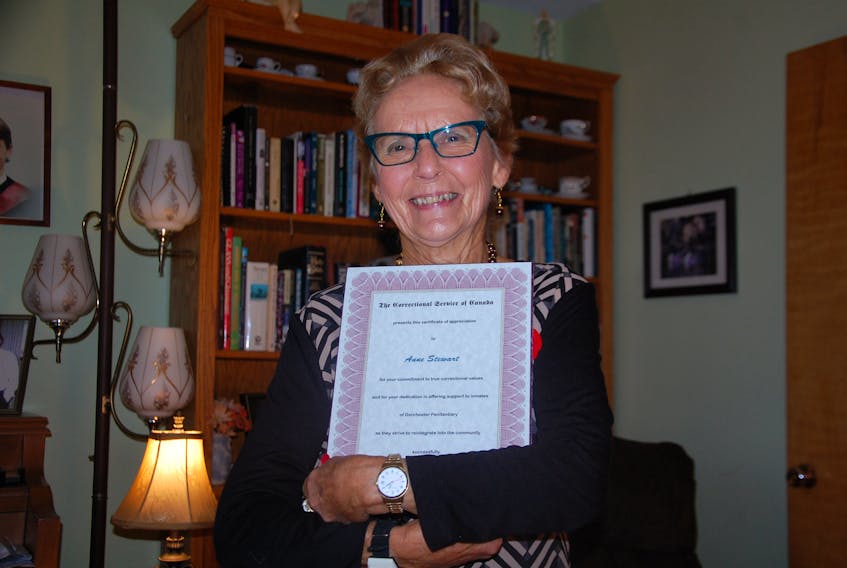 Anne Stewart-Hume of Murray Harbour proudly embraces a certificate award by Correctional Service of Canada for her dedication in offering support to inmates of Dorchester Penitentiary.