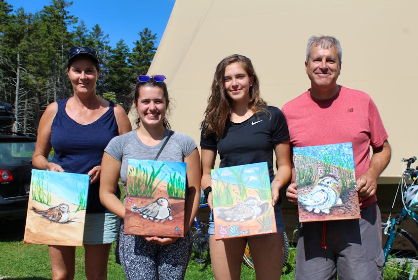 Madeleine Picard, left, Léo Picard, Christine Picard and Sophie Downer hold up their versions of the piping plover which they painted at Cavendish Campground during the Great Island Campout.