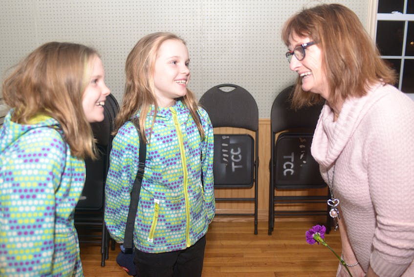 Wanda McInnis, an unlicensed home childcare provider, chats with sisters Alexis, left, and Brooklyn Pirch following a community meeting at Tracadie Rec Centre on Sunday night. McInnis, who used to look after the two sisters, is calling on the province to relax the rules for rural providers due to the lack of childcare in some areas of P.E.I.