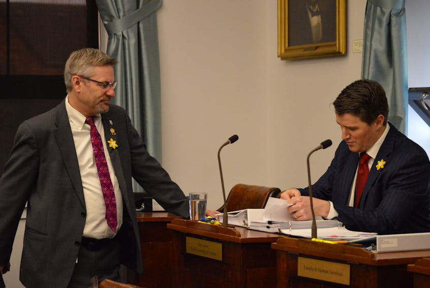 Justice Minister Jordan Brown, right, looks through some documents prior to Tuesday’s question period as Liberal MLA Robert Henderson looks on. Brown was grilled by opposition and third party members on Tuesday over the financial threshold for Islanders seeking legal aid and the exclusion of two recommendations from P.E.I.’s Conflict of Interest Commissioner in proposed legislation to amend the province’s Conflict of Interest Act.