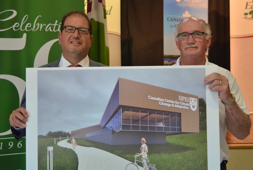 Adam Fenech, left, director of the climate research laboratory at UPEI, and St. Peters Mayor Ronnie MacInnis hold up an architect’s drawing of the new $18.5 million Canadian Centre for Climate Change and Adaptation that will be located in the north shore community. The 45,000-square foot building will serve 40 students a year and feature a student residence. Dave Stewart/The Guardian