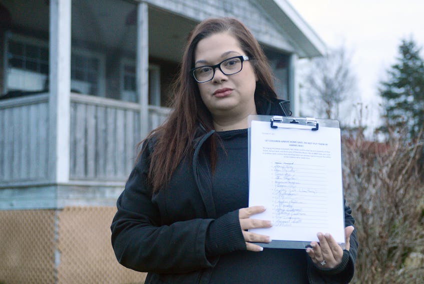 Parent Kerri Kelly holds a petition with the signatures of residents who live on and near the private road, Pine Street, in Brackley, stating they do not have an issue with a school bus going down the road. Currently, the bus stop is located before the road and right next to a convicted sex offender’s home.