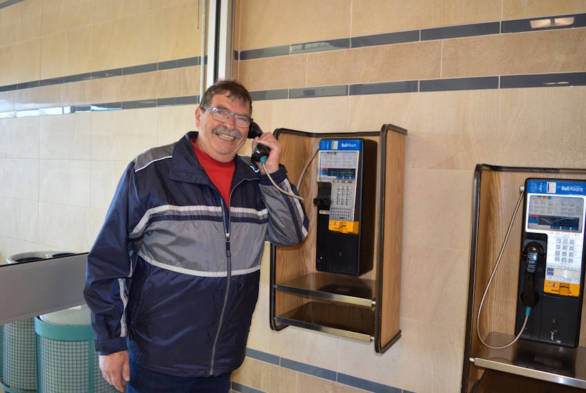 Hans Reist, who is visiting the Island from Switzerland, resorts to using a pay phone at the Charlottetown Mall this week after his prepaid cellphone wouldn’t work.