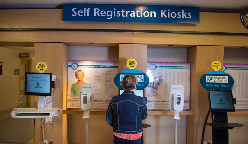 Judi Randell, manager of registration for the Nova Scotia Health Authority, shows how to use the self-registration kiosk inside Halifax’s Centennial Building at the Victoria General Hospital site in Halifax on Wednesday.