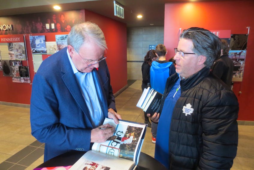 NHL legend Ken Dryden, left, signs a book for George Halliwell at Red Shores Racetrack and Casino in Charlottetown on Saturday where Dryden spoke about his latest book, “Game Change: The life and death of Steve Montador and the future of hockey.” (Bradley Collins/The Guardian)
