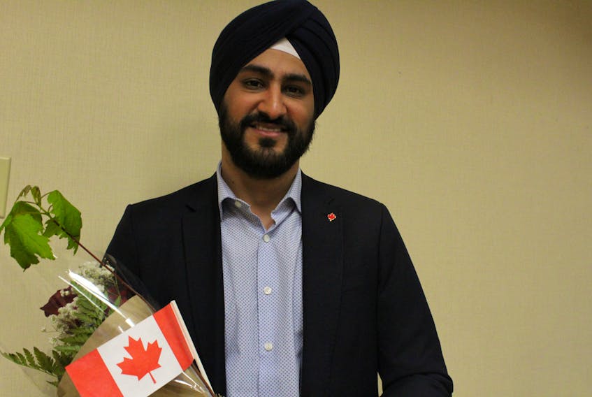 New Canadian Gagandeep Sengal holds flowers, a Canadian flag and a tree from the department of Workforce and Advanced Learning encouraging Sengal and other new citizens to plant their roots in P.E.I. June 7 at the Charlottetown Inn and Conference Centre.