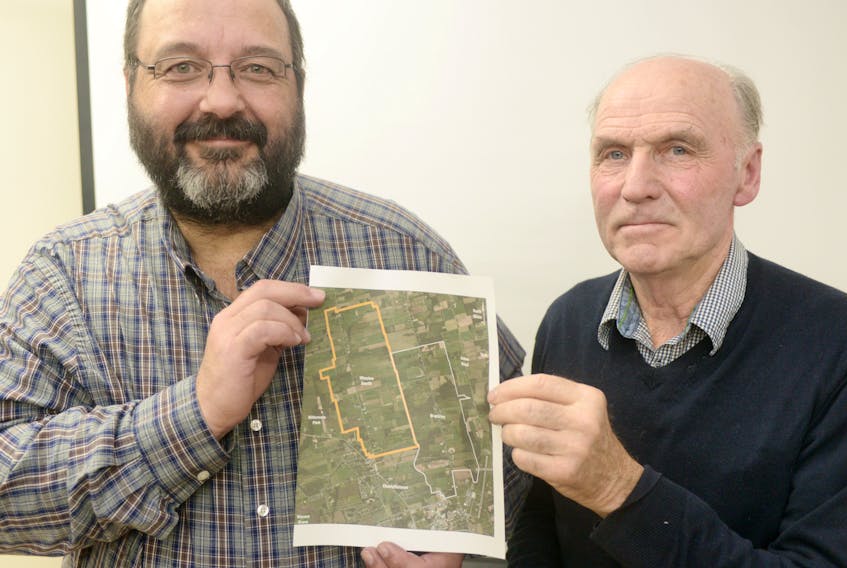 Brackley council chair Chris Beer, left, and Winsloe South chair Brian D. Turner hold a map outlining the two communities following unanimous votes by both councils to send a request to the province asking to be amalgamated. The vote came during special meetings by both councils on Wednesday night, which were preceded by a meeting seeking public feedback.