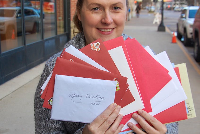 Suellen Clow-Munro, sales and marketing manager of The Holman Grand Hotel, fans out some of the many Christmas cards collected at the hotel that will soon be delivered to residents of Andrews of Charlottetown and Andrews of Stratford.