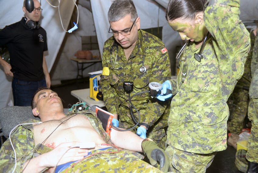 Maj. Trevor Jain shows Pte. Ashley Conrad how to assess a patient during the medical station aspect of the simulation. Jain is also a program director of the bachelor of science in paramedicine at UPEI, a medical director of paramedicine at Holland College, an emergency physician at the Queen Elizabeth Hospital and an assistant professor of emergency medicine at Dalhousie University.
