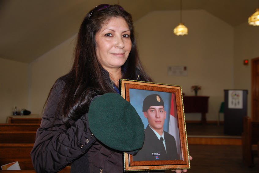 Gloria Bernard of Scotchfort holds a photo of her late son Erik Bernard and the hat from his military uniform. She says he son grew playing soldier before enlisting in the army with the simple hope of helping people.