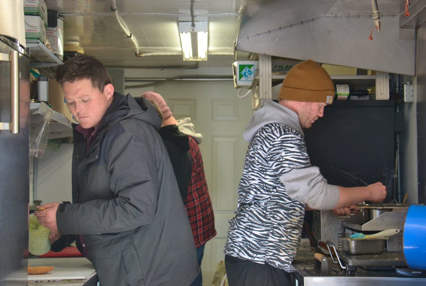 It’s business as usual on Tuesday for Nimrods’ and co-owners Mikey Wasnidge, left, and Jesse Clausheide, shown at work in their truck’s kitchen at its current location on the corner of Allen Street and St. Peters Road in Charlottetown.