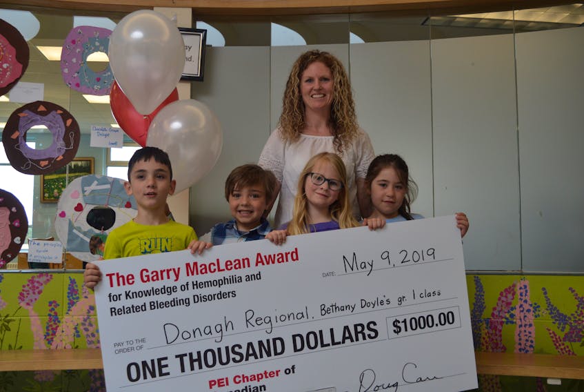 Bethany Doyle is shown with some of her Grade 1 class at Donagh Regional School as they proudly display the $1,000 cheque they were awarded by the P.E.I. chapter of the Canadian Hemophilia Society for bringing awareness to the disorder. The students pictured are, from left, Ezra DesRoches, 6, Mason Doran, 6, Hope Quinn, 6, and Kally MacDonald, 6.