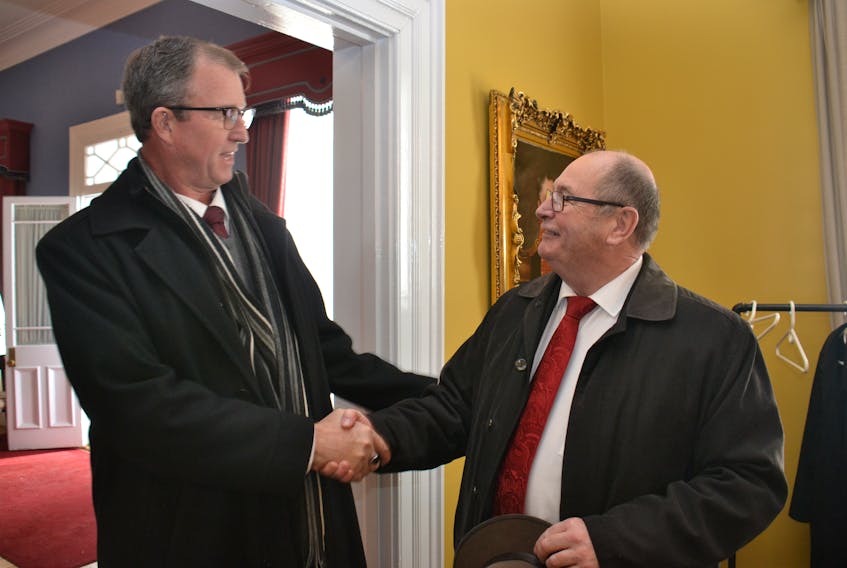 Two outgoing cabinet ministers Alan McIsaac, left, and Allen Roach, wish each other well at Government House on Wednesday, where Premier Wade MacLauchlan announced a cabinet shuffle.