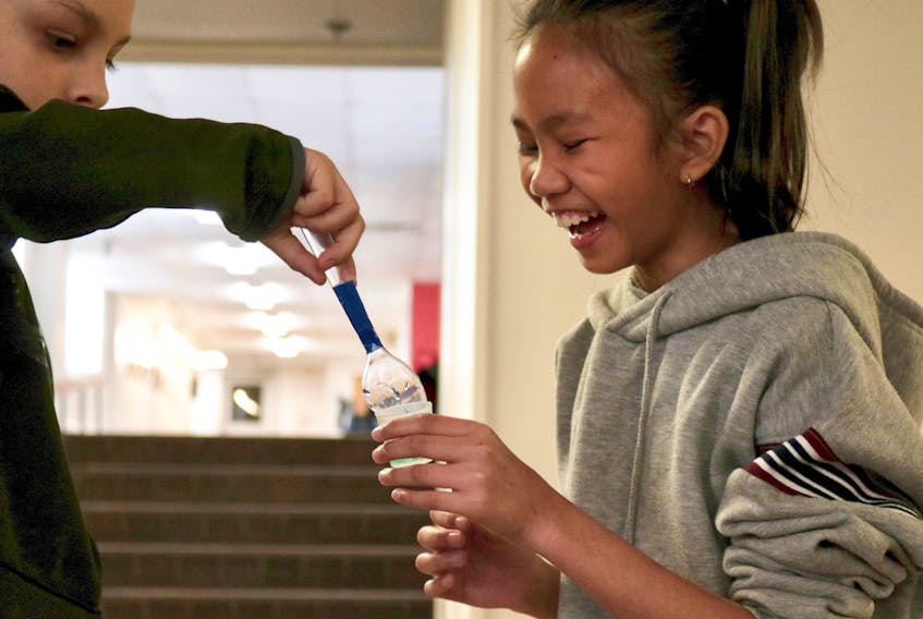 Parkdale Elementary student Sunshine Bernabe measures the volume of water saved after a tablespoon was passed around between her classmates. The Grade 5 class was at Holland College, learning about water conservation.