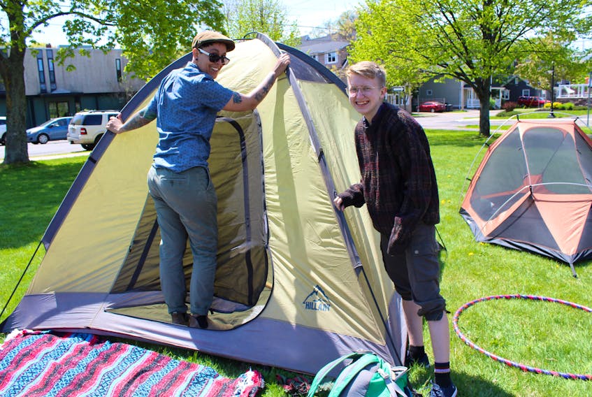 Dee Miguel, with P.E.I. Fight for Affordable Housing, helps Kels Smith, right, set up her tent for the Town of Discontent event on Saturday.