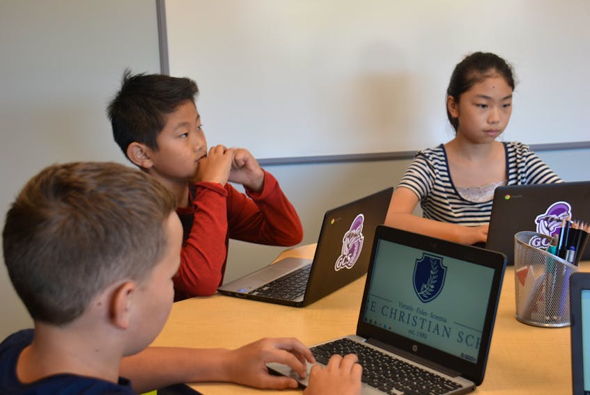 Jayden Somers, left, Jason Sin, and Kate Shi, right, work on their new Chromebooks in a newly remodelled classroom at Grace Christian School on Sept. 10. Kai Vere/The Guardian
