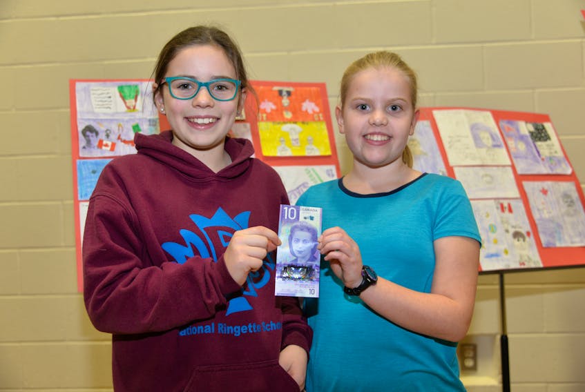 Stratford Elementary School students Sophie Gallant, left, and Ella Chapman hold the new Viola Desmond $10 bill.
