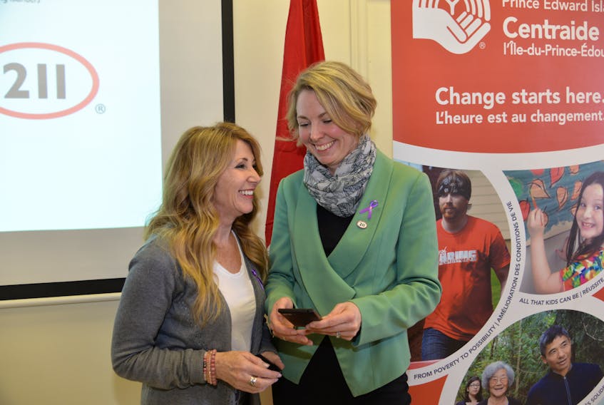 Family and Human Services Minister Tina Mundy, left, and Andrea MacDonald, CEO of the United Way of P.E.I., are shown at Monday’s funding announcement for a new 2-1-1 service for the Island, expected in the fall.