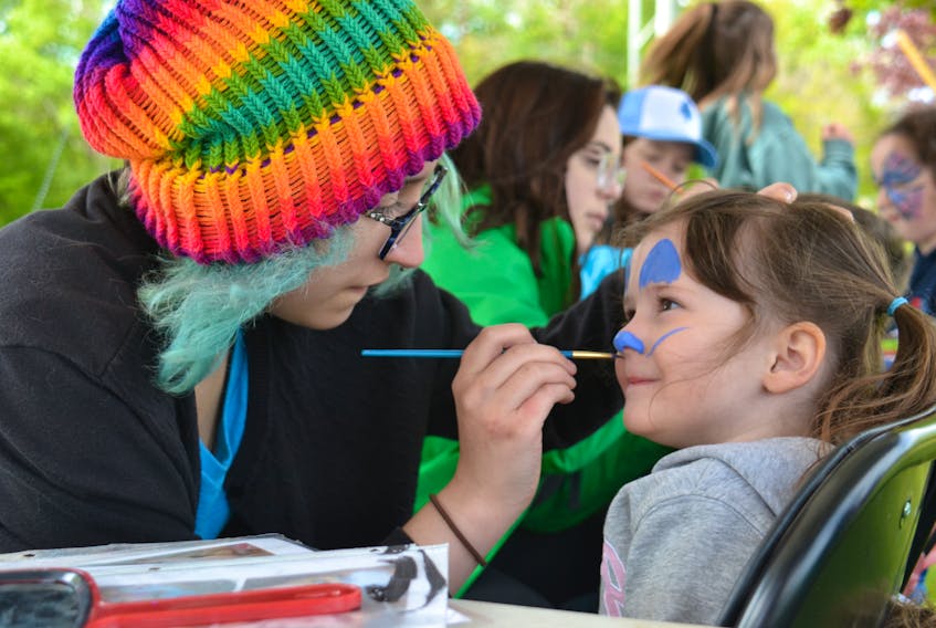Three-year-old Emily Loughran of North Wilshire gets her face painted by Maddy Bedard-Adam during Charlottetown's Natal Day celebrations at Victoria Park on Sunday.