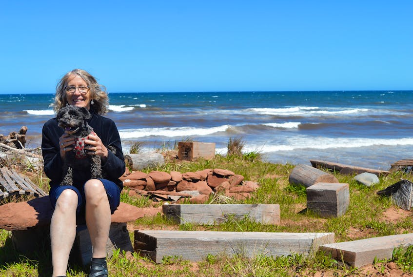 Sandra Fraser, pictured here with her dog, Silvie, has found peace amid the crashing waves at the Rock Barra Retreat in eastern P.E.I. She sits at the hot rock where groups have bonfires or take part in chanting exercises or simply play some guitar.