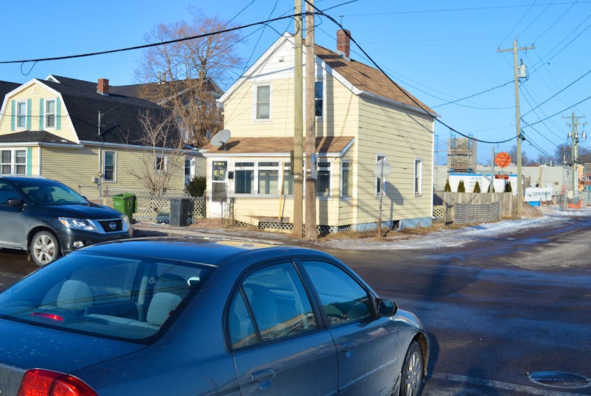 Vehicles can be scene at the intersection of Queen and Pond streets in Charlottetown on Tuesday. City council agreed Monday night to purchase the yellow home at the corner in an effort to improve sightlines at the intersection.