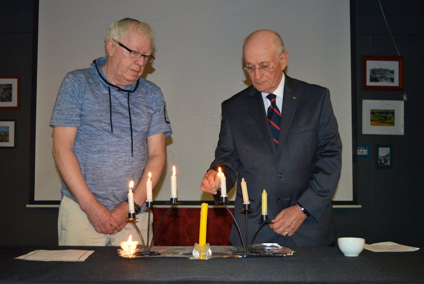 Winston Macgregor, left, president of the P.E.I. Jewish Community, watches as Holocaust survivor Israel Unger lights a candle during the memorial candle-lighting ceremony to mark Yom HaShaoh Holocaust Remembrance Day. Unger, who was born in 1938 in Tarnow, Poland, was the honoured speaker during the ceremony at the Confederation Centre of the Arts in Charlottetown Thursday.