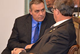 Environment Minister Robert Mitchell speaks with Liberal MLA Alan McIsaac in the P.E.I. legislature in this file photo.