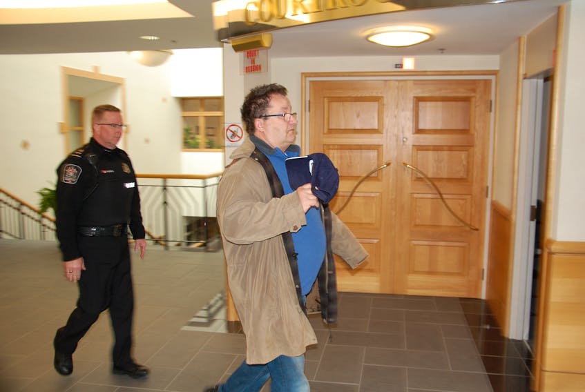 Leo Dowling, right, heads into court Thursday where he was sentenced to two years in a federal correctional facility after being found guilty in May of 15 sex offences against seven victims under the age of 16.