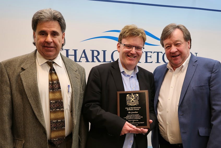 Coun. Mitchell Tweel, left, chairman of the city’s Civic Board for Persons with Disabilities, and Charlottetown Mayor Clifford Lee, right, present Wayne Thibodeau of The Guardian with an Inclusion Award on Sunday.