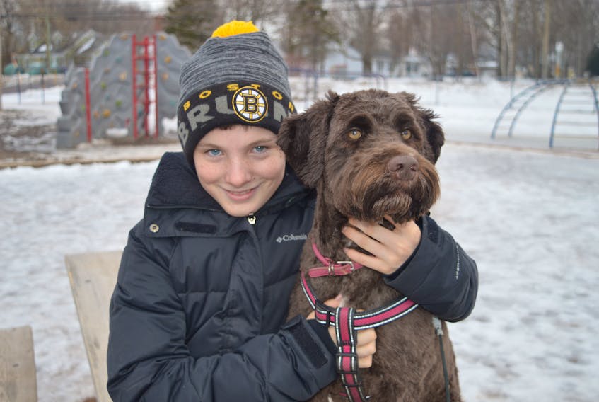Grade 6 student Nathan Wohlgemut, who is shown with his Portugese water dog, Miss Beasley, has put together a hockey game on Sunday at Sherwood Elementary School in Charlottetown that will act as a fundraiser for the P.E.I. Humane Society.
