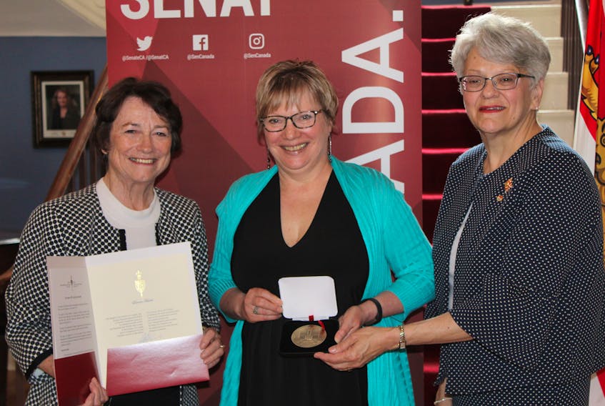 Doreen Huestis, centre, receives a Senate 150 medal from Lt.-Gov. Antoinette Perry, right, and Sen. Diane Griffin. The medal program honours Canadians who have made contributions to their communities. It also commemorates the 150 years since the senate first met.