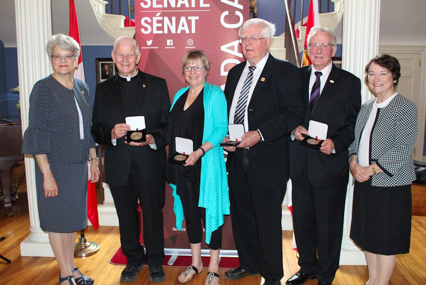 Senate 150 medal recipients meet with Lt.-Gov. Antoinette Perry, left, and Sen. Diane Griffin, right, following a ceremony at Government House. From left are Rev. J. Charles Cheverie, Doreen Huestis, Dr. Colin McMillan and John J. MacDonald.