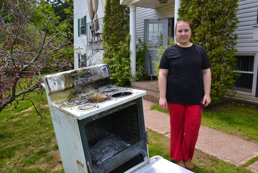 Susan Murl, superintendent of a Beach Grove apartment building, stands beside a stove that was destroyed by a fire in one of the units Friday evening.